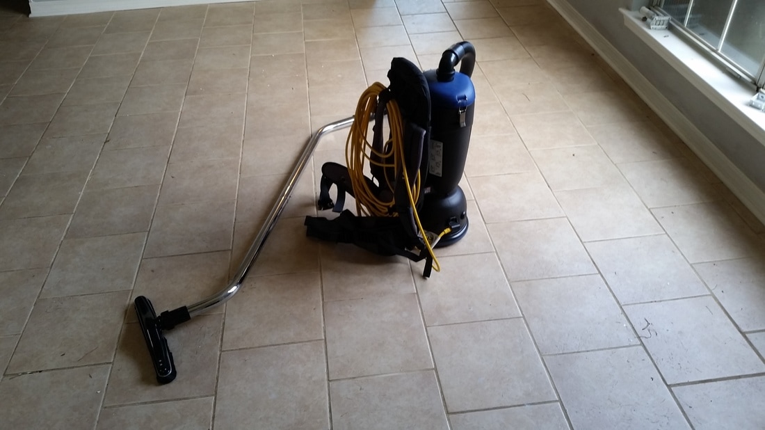 Picture of a backpack vacuum used to vacuum the tile and grout before cleaning